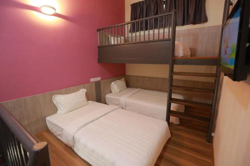 a bedroom with two beds and a bunk bed at Pantai Regal Boutique Hotel in Kuantan