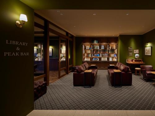 a lobby with couches and a library and a break bar at Infinito Hotel and Spa in Shirahama