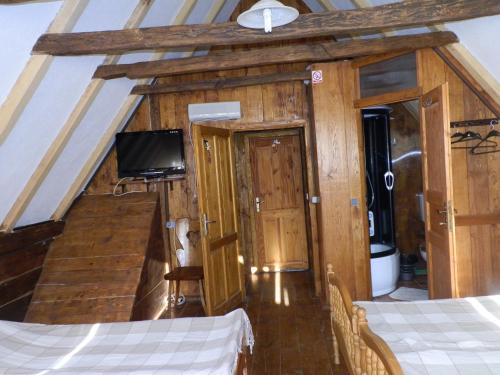 a room with a bed and a flat screen tv at Tradicije Cigoc in Čigoč