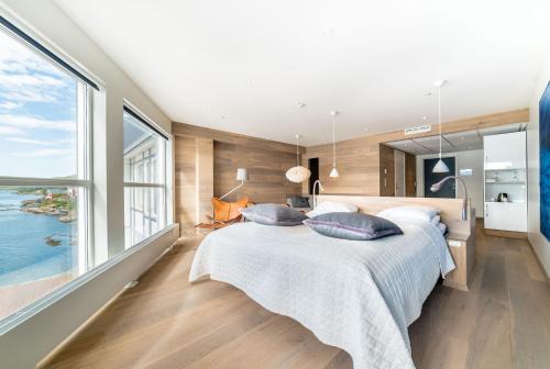 a bedroom with a large bed and large windows at Malangen Resort in Mestervik