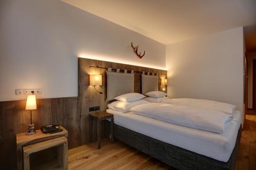 a bedroom with a large bed with white sheets and pillows at Kösslerhof in Sankt Anton am Arlberg