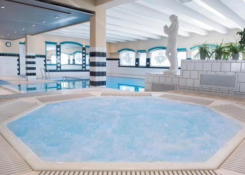 a large swimming pool with a statue in a building at Fleischer's Motel in Vossevangen