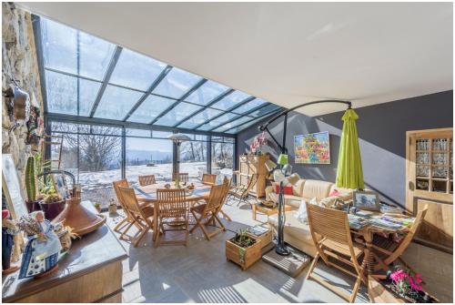 - un salon doté d'un plafond en verre avec une table et des chaises dans l'établissement Château Serigues, à Gap