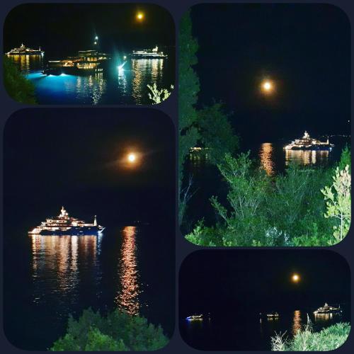 four pictures of a boat on the water at night at Foki Beach House in Fiskardho