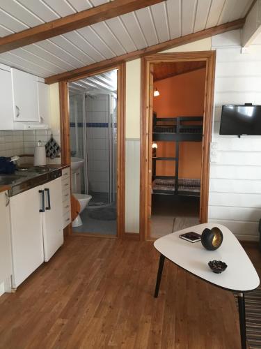 a kitchen with a table in the middle of a room at Valla Stuga in Kristinehamn