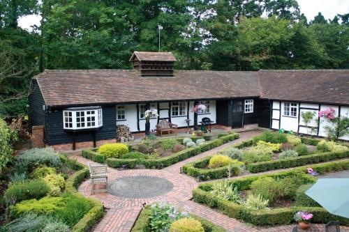 a garden in front of a black and white house at White Lodge Cottage in Guildford