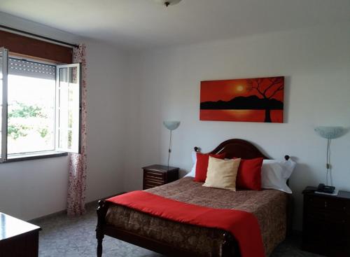 una camera con un letto con una coperta rossa di Hotel Branco II a Praia da Vitória
