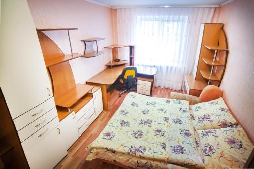 ヴィーンヌィツャにあるApartment on Lyali Ratushnoyのベッドとデスクが備わる小さな客室です。
