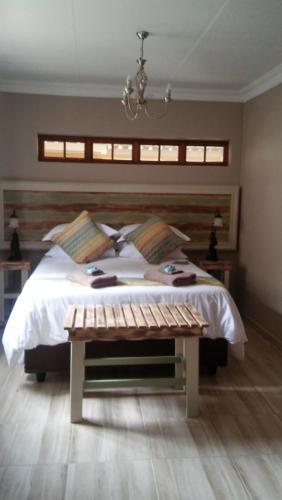 a bedroom with a large bed and a table at hanna's place in Polokwane
