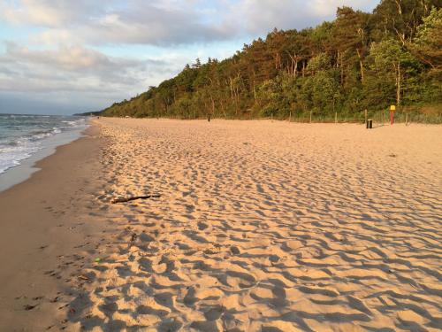a sandy beach with footprints in the sand at Domki "Arkadia" in Pobierowo