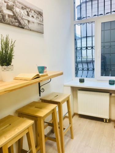 a room with wooden tables and benches and a window at Laisves Avenue Hostel "Easy Kaunas" in Kaunas