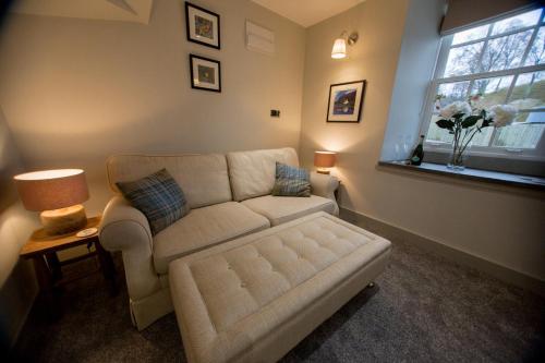 a living room with a couch and a window at Cairn Leuchan in Ballater