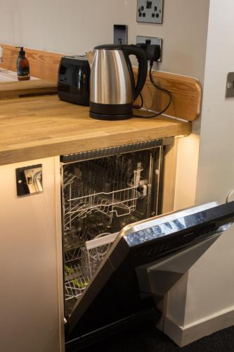 a dishwasher with its door open in a kitchen at Cairn Leuchan in Ballater