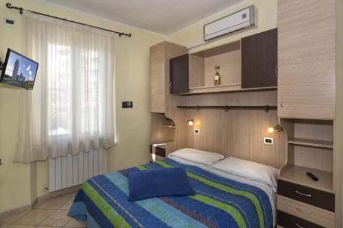 a hotel room with a bed, television and a desk at Affittacamere Elisa in Pisa