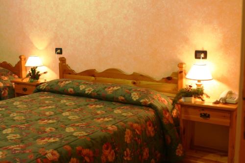a bedroom with a bed and two night stands with lamps at Hotel Centrale in Gambarie dʼAspromonte