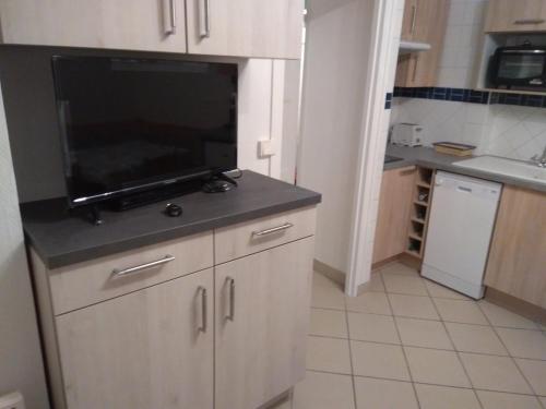 uma cozinha com uma grande televisão de ecrã plano num balcão em FLAB' MARIN em Le Tréport