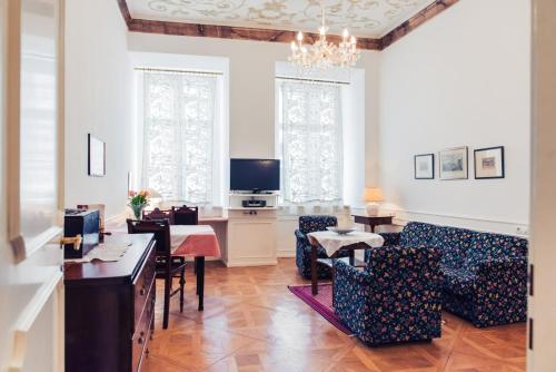 a living room with a table and chairs and a television at Ofenloch Apartments in Vienna