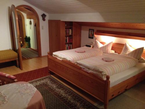 ein Schlafzimmer mit einem großen Bett und einem Spiegel in der Unterkunft Gästehaus Färbinger in Bayerisch Gmain