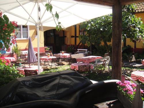 a patio with tables and chairs and an umbrella at Hotel Klostergaarden in Allinge
