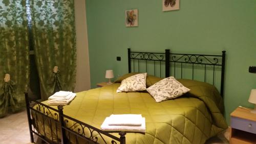 een slaapkamer met een geel bed en handdoeken bij BBCinecitta4YOU in Rome