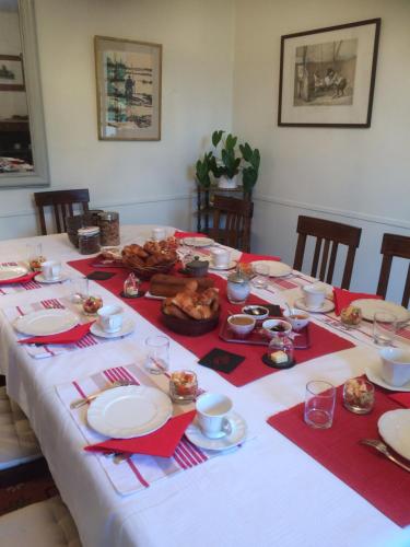 een tafel met een witte tafeldoek met voedsel erop bij Chambre D' Hôtes La Lucasserie in Saumur