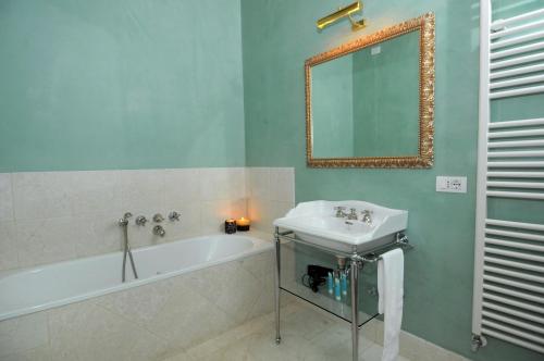 a bathroom with a sink and a tub and a mirror at Ca' dell' Artista with Balcony and Terrace in Venice