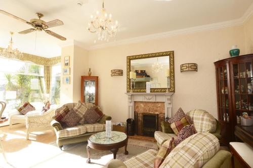 a living room with a fireplace and a mirror at The Cleveland in Torquay