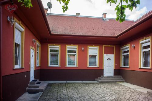 Cívis Szálláshely في ديبريتْسين: منزل برتقالي مع سقف احمر
