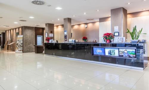 a lobby of a hotel with a reception counter at BLUESEA Gran Cervantes in Torremolinos