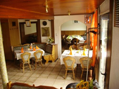 ein Restaurant mit zwei Tischen und Stühlen und einer Couch in der Unterkunft Hotel Kraichgauidylle in Malsch