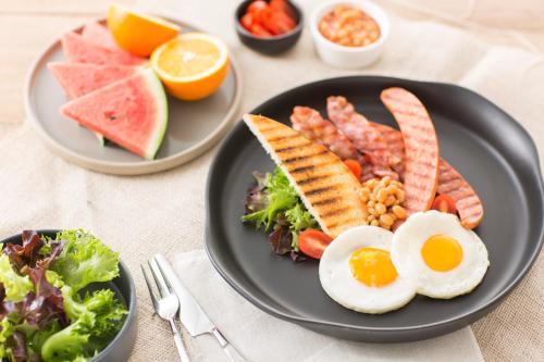 华欣帕斯卡尼度假村的包括鸡蛋培根和蔬菜的早餐食品