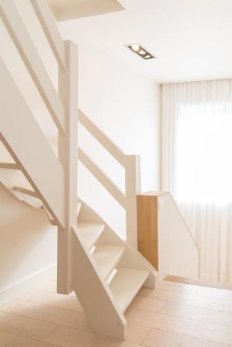 białe schody w pokoju z oknem w obiekcie La Mer w mieście De Panne
