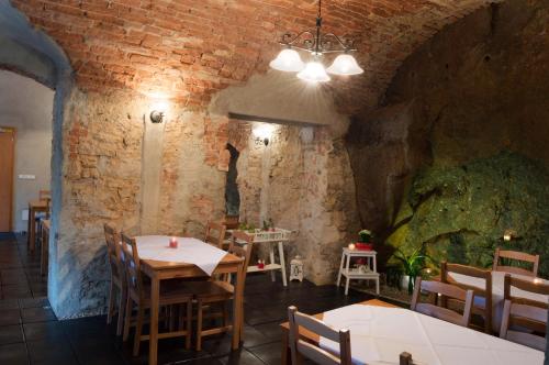 a restaurant with tables and chairs and a brick wall at Penzion Ve Skale in Loket