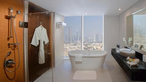 a bathroom with a toilet and a sink and a shower at Millennium Central Downtown in Dubai