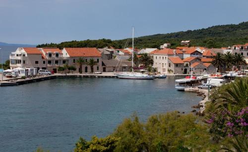 a river with boats in a town with houses at Apartments Toplak in Sućuraj