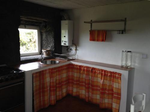 a small kitchen with a sink and a window at Casa Da Lava in São Roque do Pico