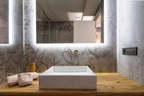 uma casa de banho com um lavatório branco e um espelho. em My Lovely Place Navigli em Milão