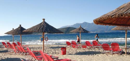 a group of chairs and umbrellas on a beach at TETYK Keramoti Hotel Apartments in Keramotí