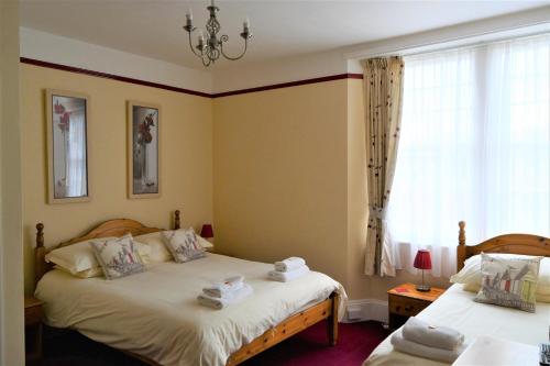 a bedroom with two beds and a window at St Marguerite in Paignton