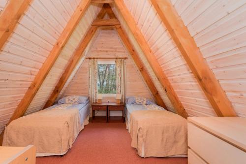 a room with two beds and a table in a attic at Gryf Domki Pobierowo in Pobierowo