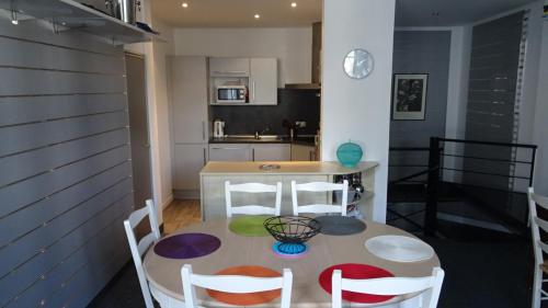 une salle à manger avec une table et des chaises et une cuisine dans l'établissement Appart T4 Luchon plein centre, à Luchon