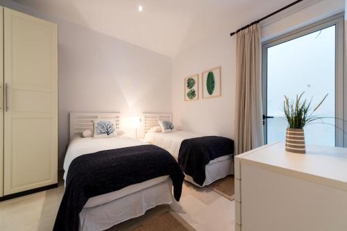 ラスパルマス・デ・グランカナリアにあるSunset Paradiseの白い部屋 ベッド2台 窓付