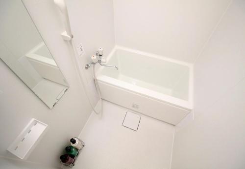 a white bathroom with a sink and a mirror at Shin Okubo Sekitei in Tokyo