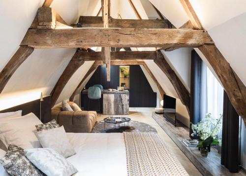 Pokój na poddaszu z łóżkiem i stołem w obiekcie Gulde Schoen Luxury Studio-apartments w Antwerpii