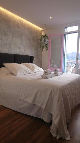 a bedroom with a large white bed with a window at Hotel San Nikolas in Hondarribia