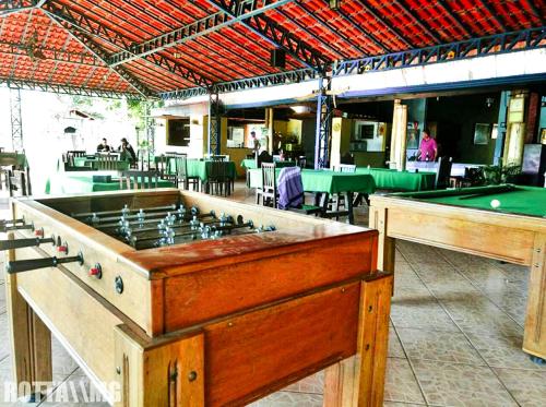 a ping pong table in a restaurant with a pool table at Pousada Portal da Serra in São João Batista do Glória