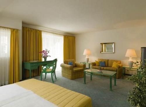 een hotelkamer met een bed en een woonkamer bij Hotel Seehof in Loibichl