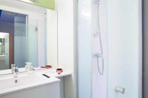 a bathroom with a white sink and a shower at ibis budget Thonon Les Bains in Thonon-les-Bains