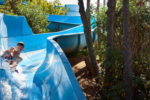 a boy on a water slide at a water park at Aldemar Olympian Village in Olympia