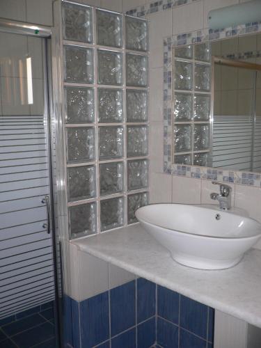 a bathroom with a sink and a glass block window at Megalos Mourtias in Alonnisos